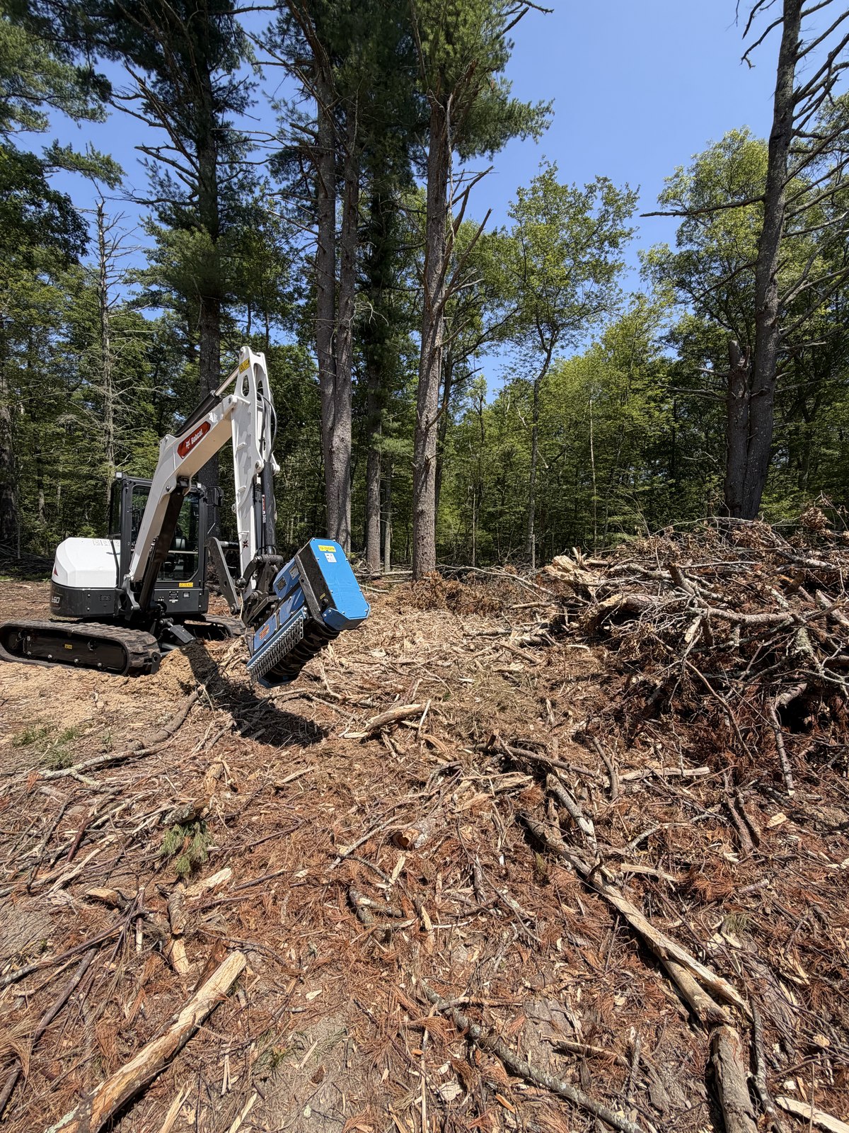 Bobcat E60 excavator with mulching head clearing brush in Foster RI